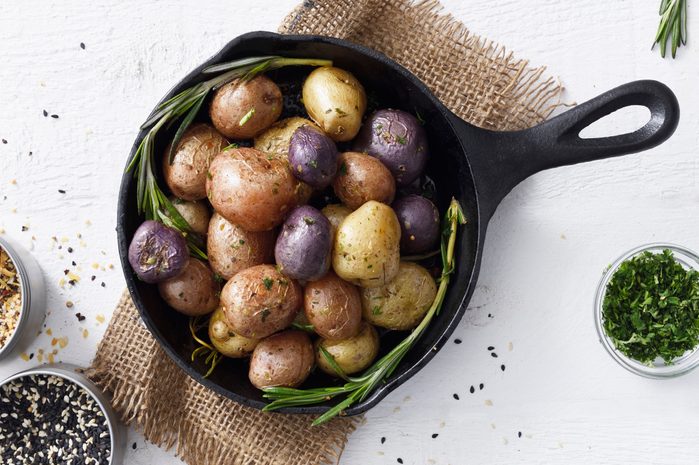 Cooked mixed colored small potatoes in a skillet