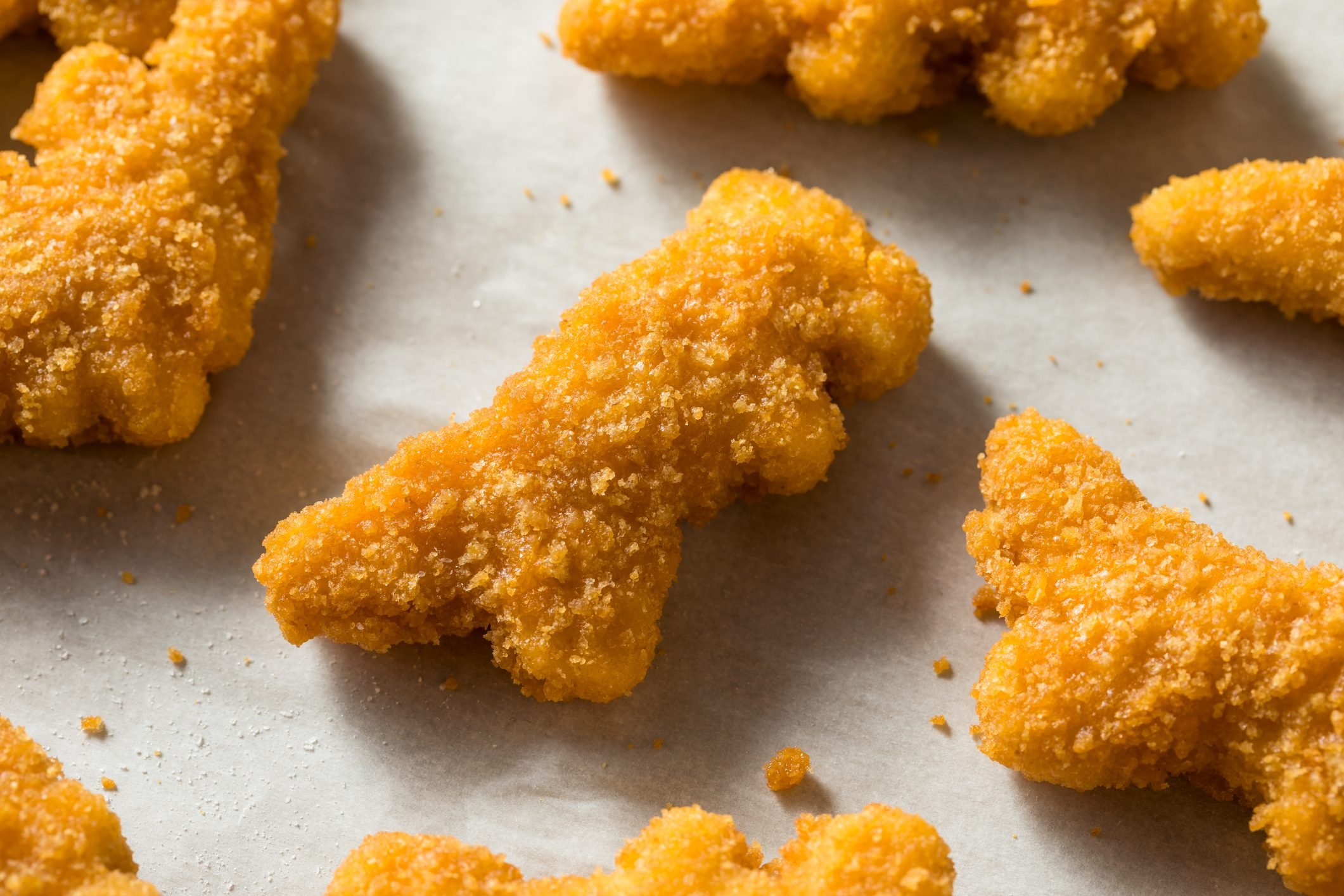 kids dinosaur frozen chicken nuggets on baking sheet