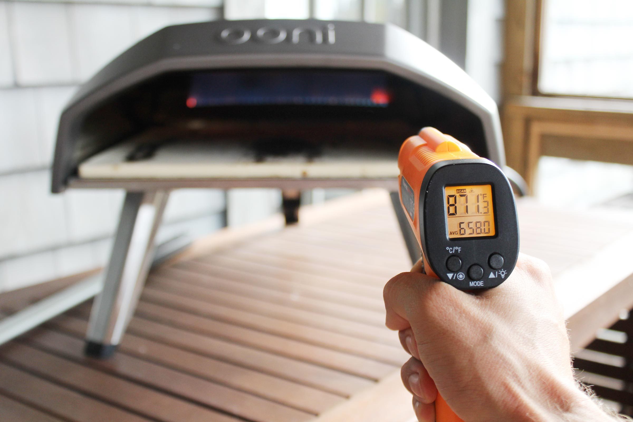 using a temperature gun to check the oonie oven temperature