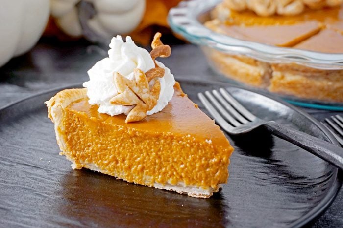 a slice of Libbys Pumpkin Pie topped with decorative leaf crust and whipped cream