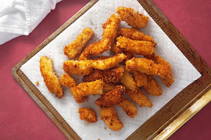 fried chicken on a paper towel and baking sheet