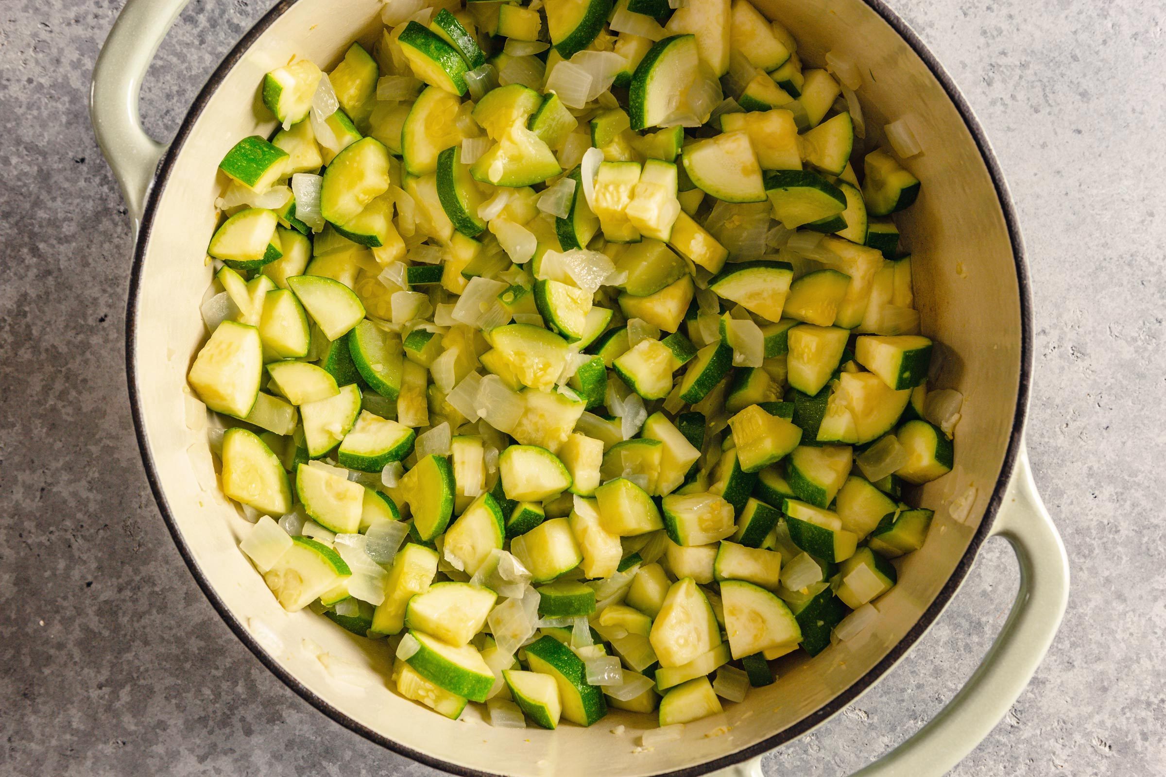 Zucchini and onion mixture in a dutch oven pot before cooking