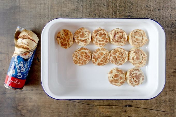 arranging cinnamon roll dough in a pan