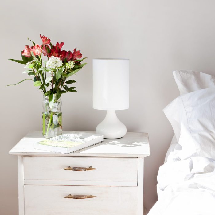 Flower arrangement on the bed side table as Morning Light In Bedroom