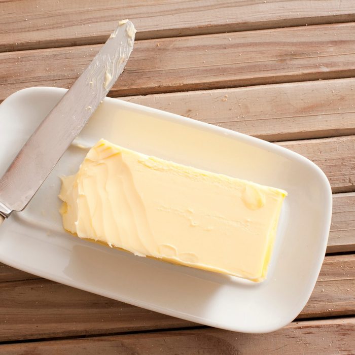 Directly Above Shot Of Butter And Knife On Wooden Table
