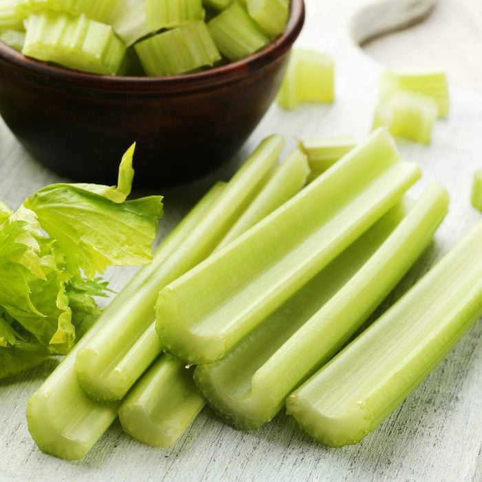 semi chopped Celery on white cutting board