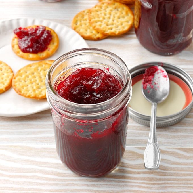 mason jar of homemade jam with crackers and a spoon to the side