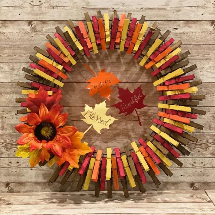 fall clothes pin wreath with faux lflowers and leaves as an accent