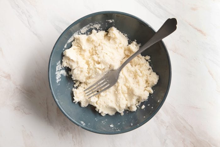mixing gluten free pie crust in a bowl with a fork