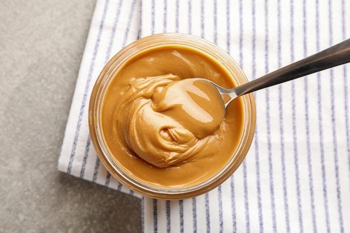 jar of peanut butter with a spoon in it, view from above