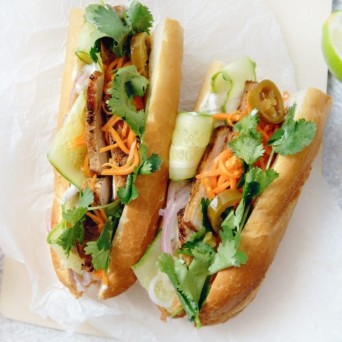 Classical banh-mi sandwich with sliced grilled pork tenderloin, shredded carrots and peeled cucumbers, jalapeno peppers and cilantro