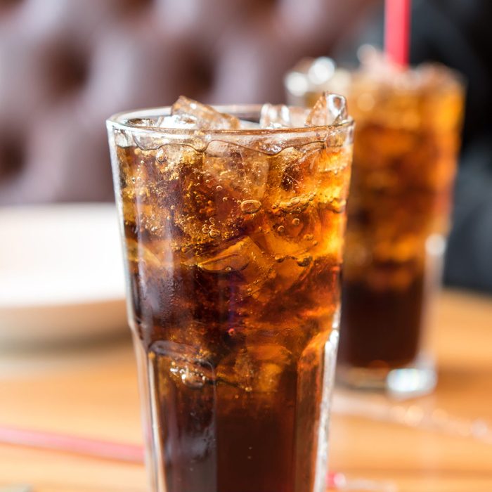 Soft drink on wooden table and men sitting