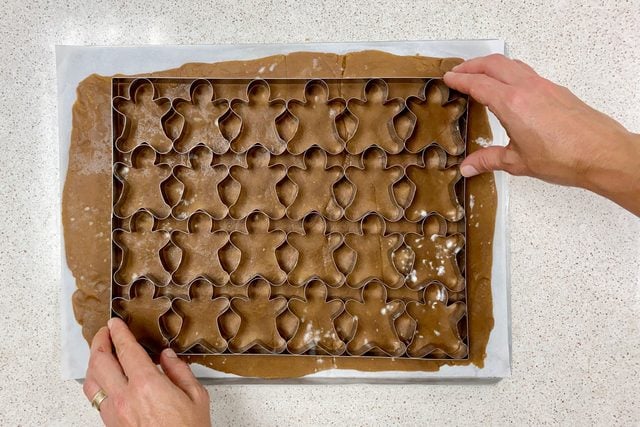 using a cookie cutter to cut out ginger bread cookies
