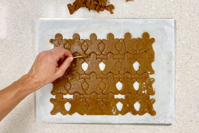 trimming excess cookie dough after using the cookie cutter