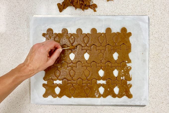 trimming excess cookie dough after using the cookie cutter