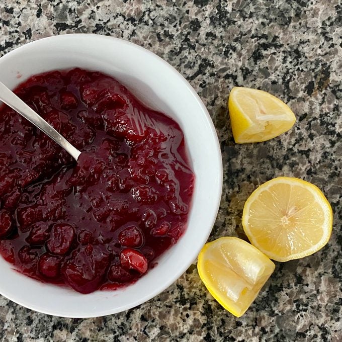Cranberry topping in a bowl with lemon slices on the side
