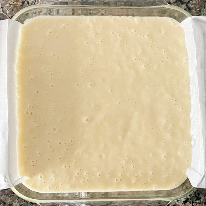 cake mix in a glass pan lined with parchment paper