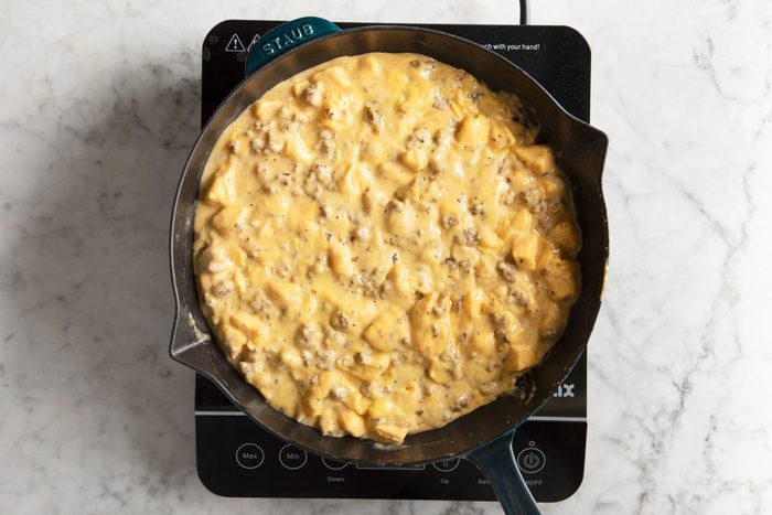 melted cheese with ground beef in a cast iron skillet