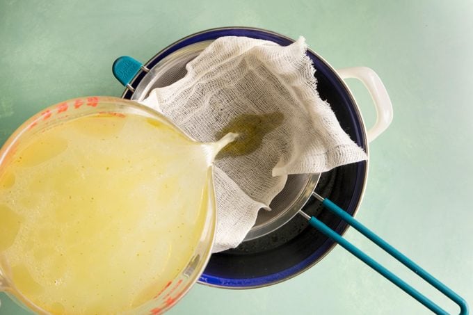 straining broth with cheesecloth 
