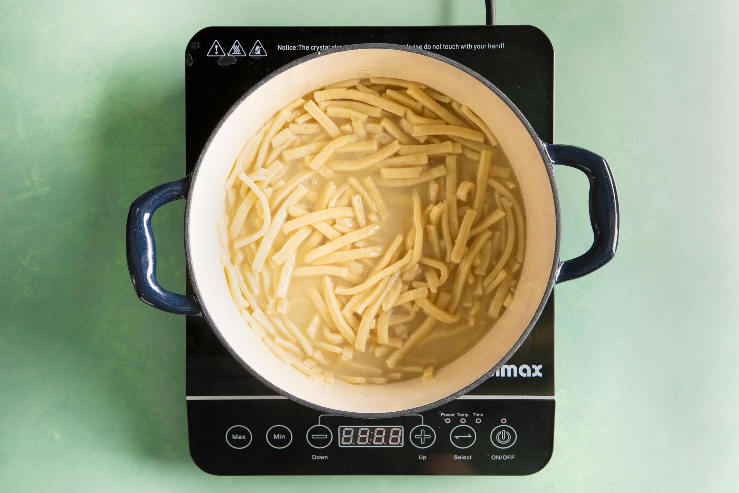 boiling noodles in a large stock pot on a hot plate