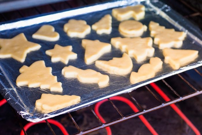 Various cookies shape on a foil lined baking sheet in an oven