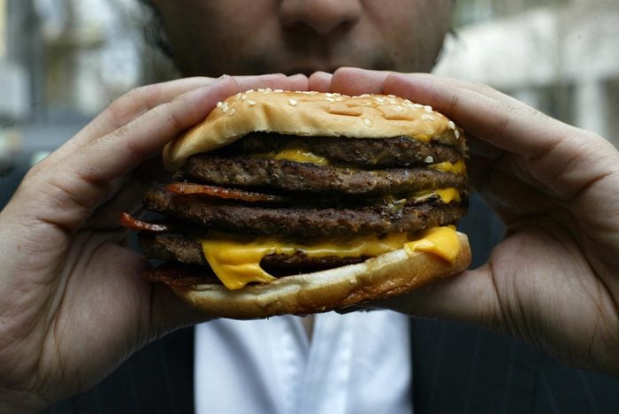 McDonalds custom burger with four beef patties, four slices of cheese and bacon.