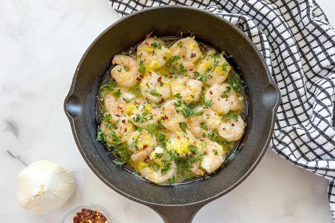 cast iron skillet with shrimp cooking