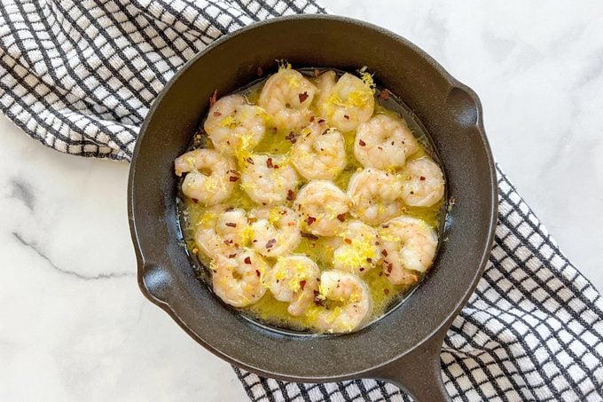 cast iron skillet with shrimp cooking