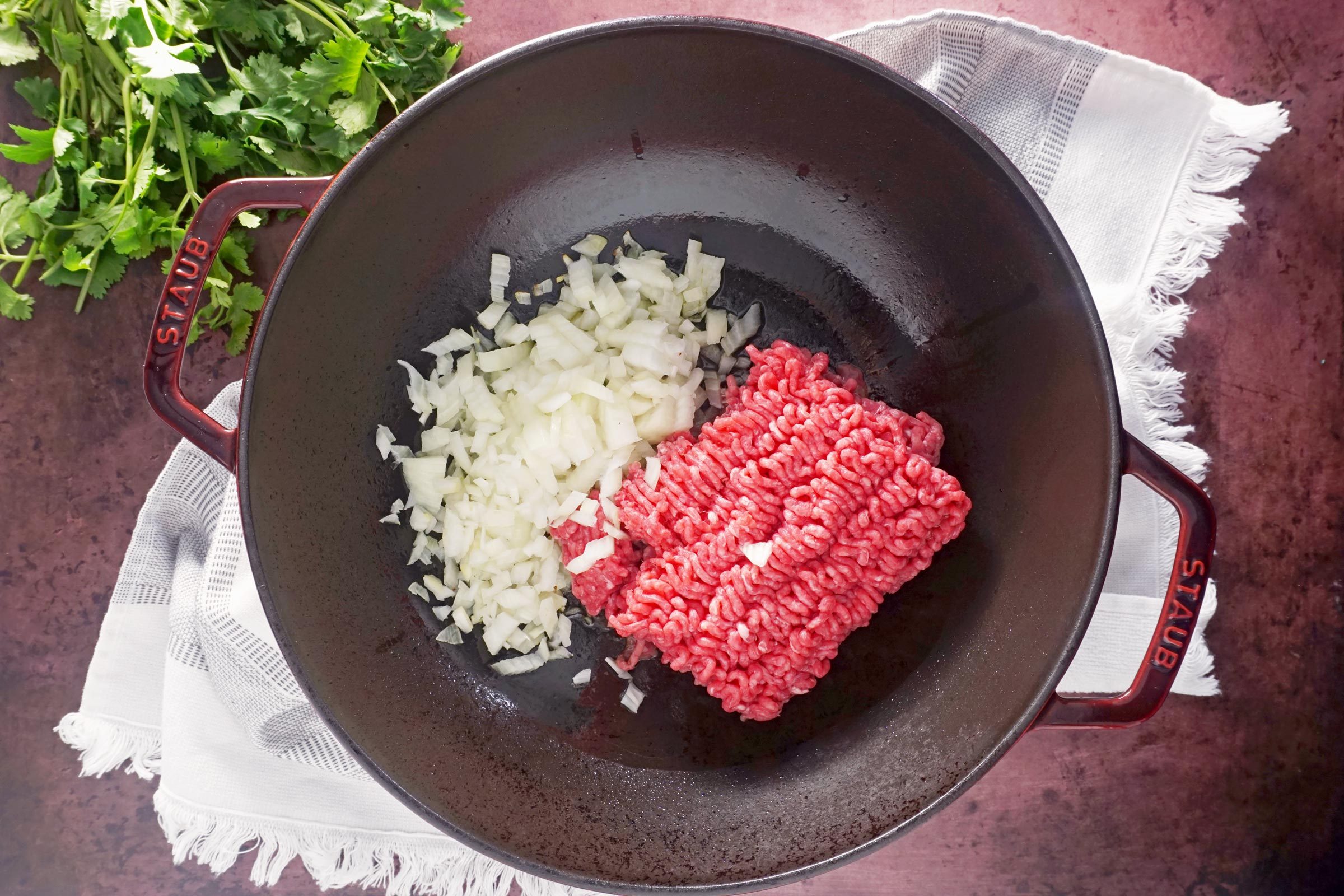 raw beef and onions in a pan before cooking