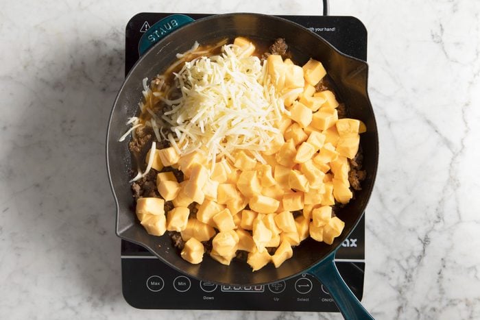 shredded cheese and cubbed cheese in a cast iron skillet before being melted