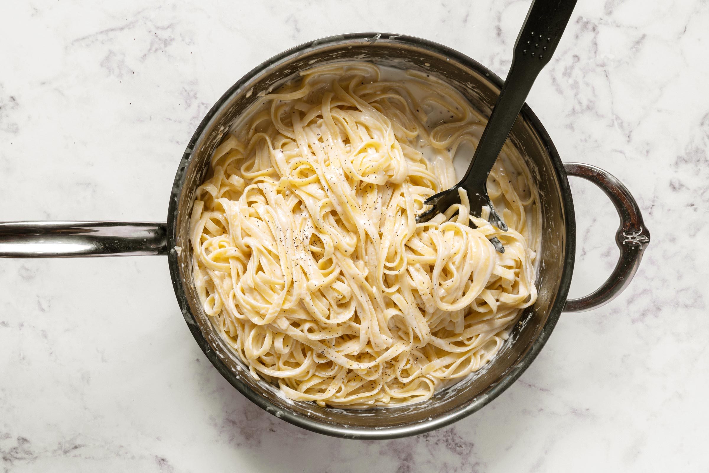 fettuccine in a pot on a marble counter