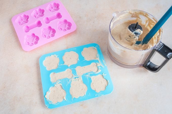 pouring dog treat smoothie into silicone molds