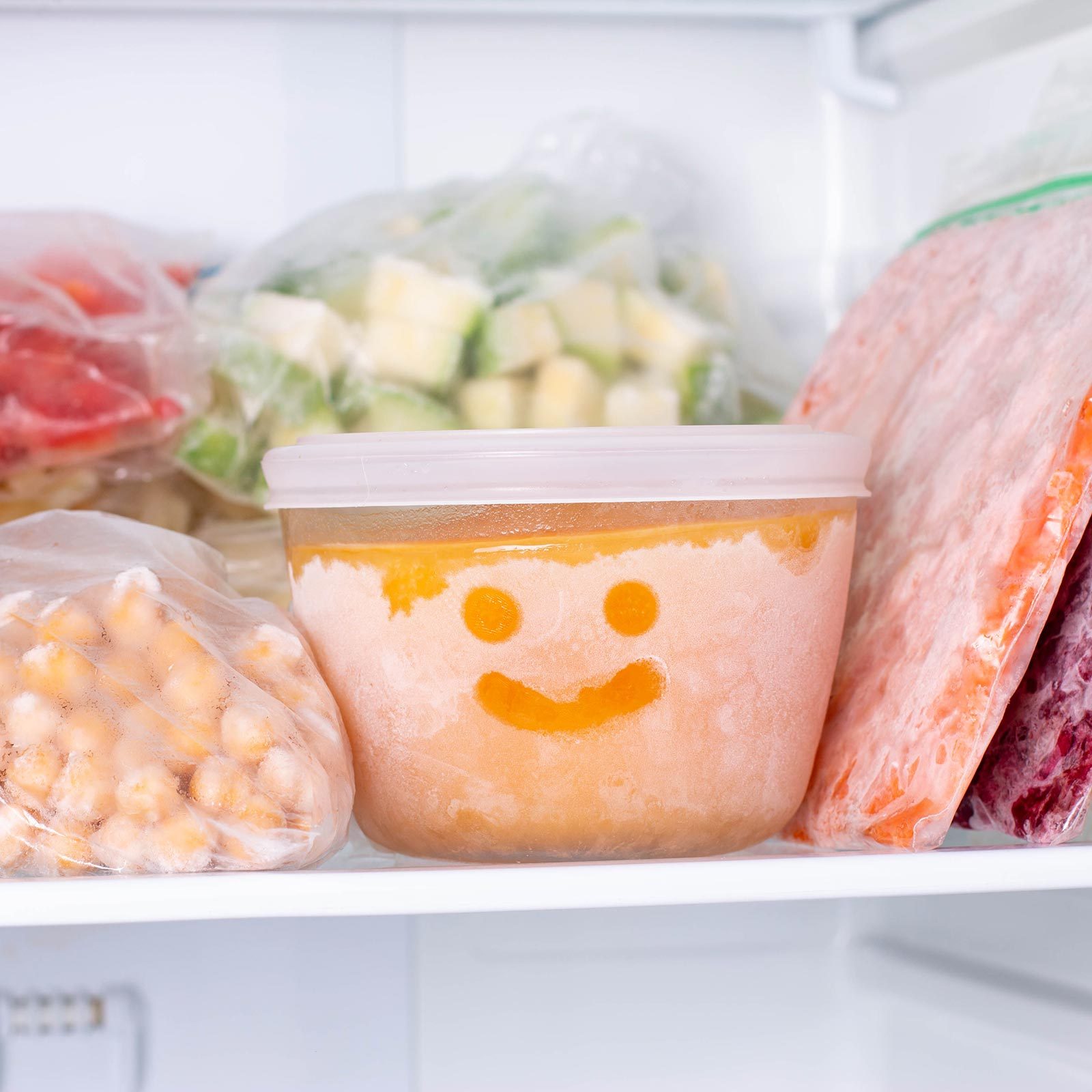 Frozen Food In The Freezer with smiley face drawn on frozen food storage bowl