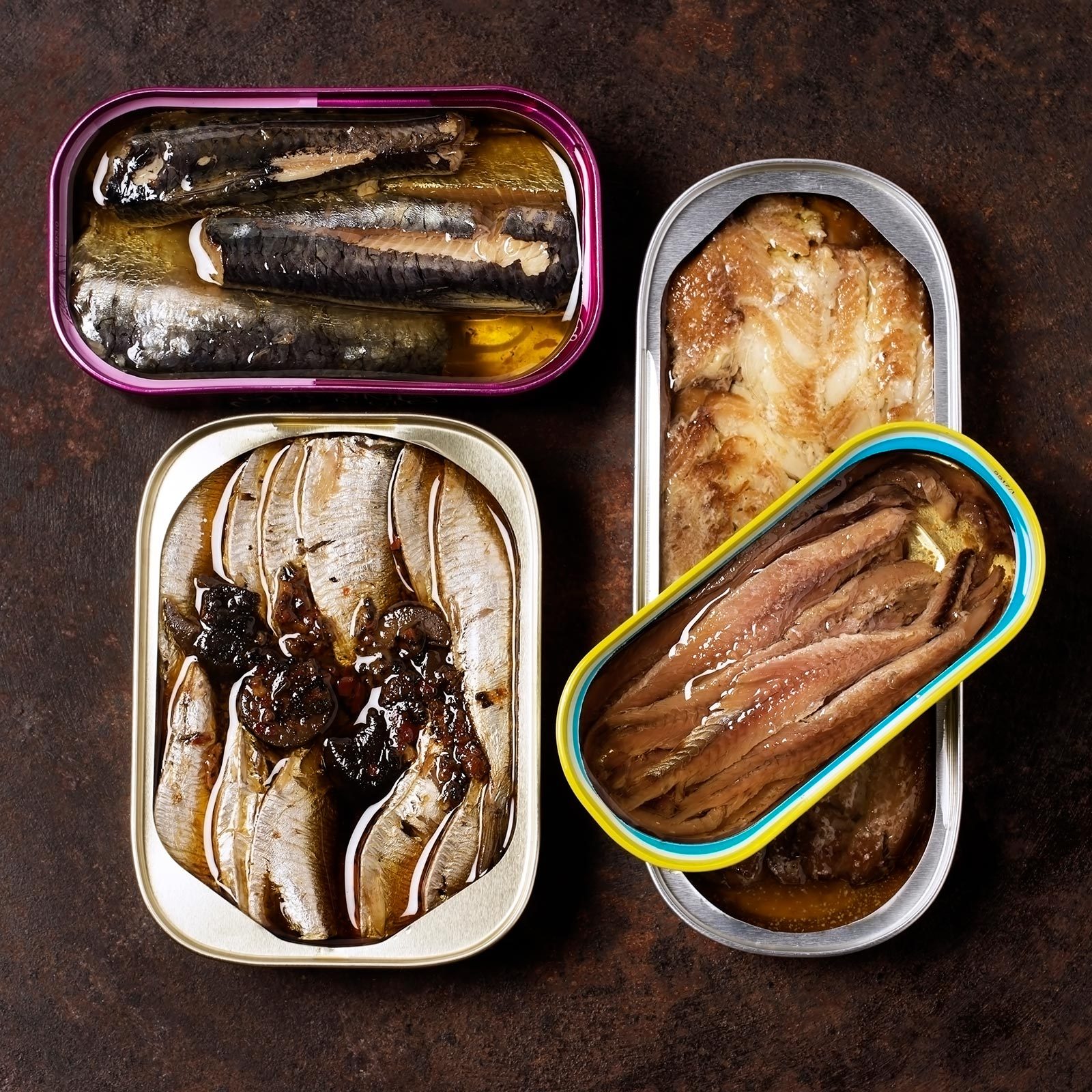Open Canned Fish Tins on a metal background