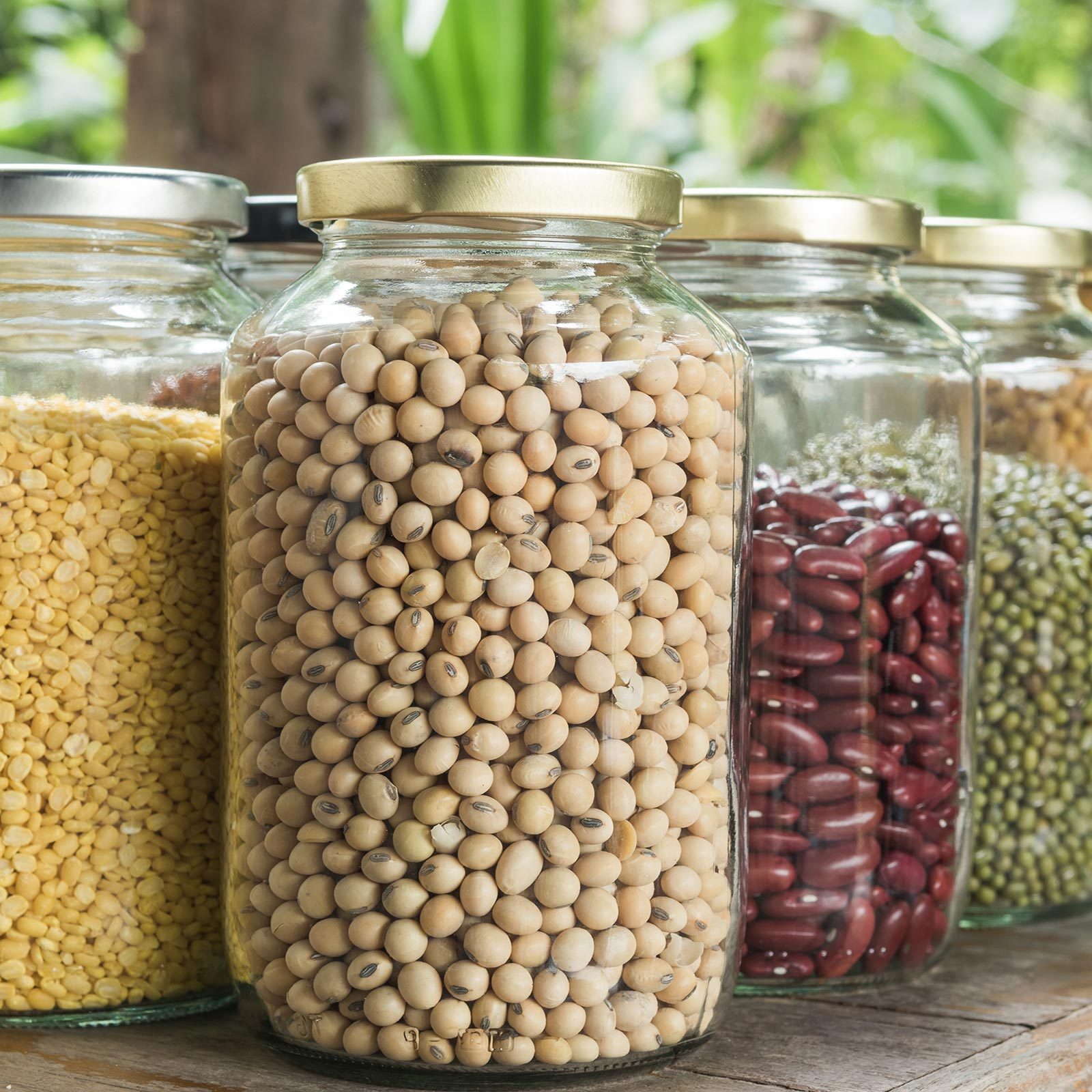 Various Dry Legumes In Glass Jar on wooden table