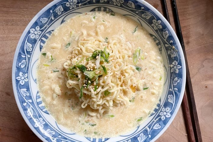 top view of a bowl of ramen made fancy with mayonnaise and scallions