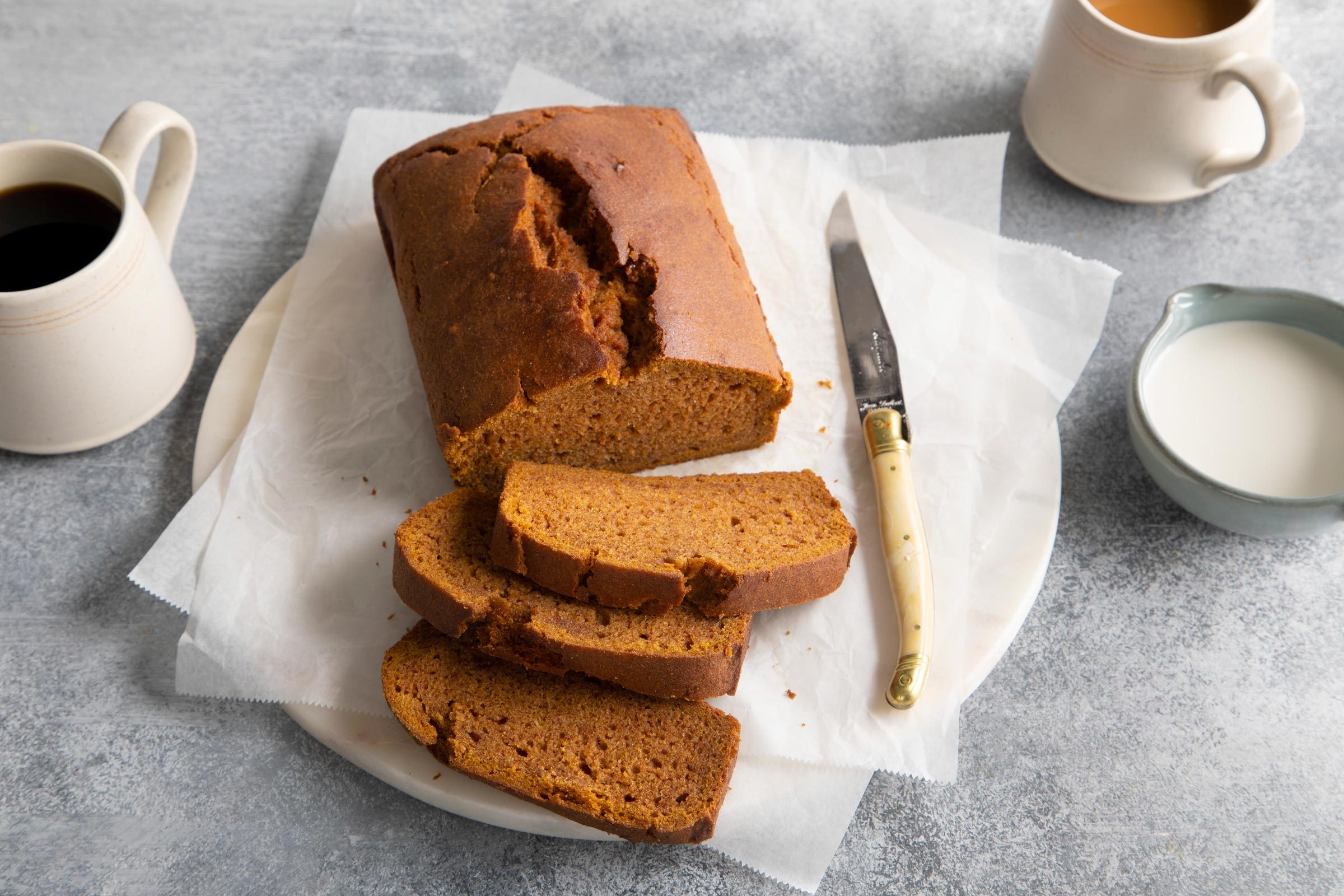 slices of gluten free pumpkin bread with half of an unsliced loaf
