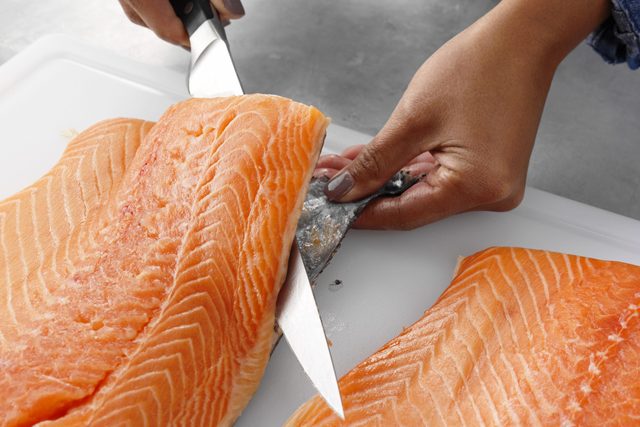 Take the skin off the salmon with one hand cutting the skin with a kitchen knife and the other keeping the skin taught for easier slicing