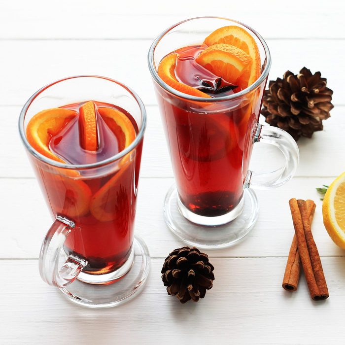 Two glasses of bourbon hot toddy with oranges and cinnamon sticks for garnish