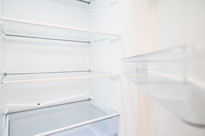 Empty clean refrigerator with open door.