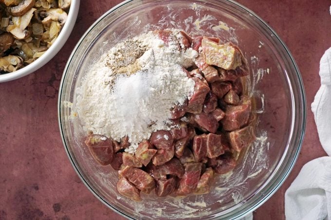 seasoning the meat in a glass bowl