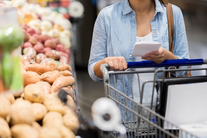 Unrecognizable woman choosing produce at grocery store