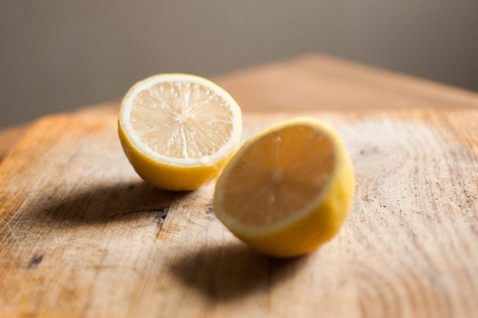 A lemon on a wooden cutting board