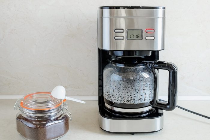 And finally drip-type coffee maker brews coffee for the first time. Red button indicates process is going on. Hot coffee is in glass jug. Home electrical appliances. Domestic life.