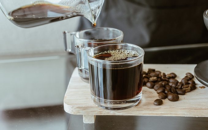 Cropped shot of Barista pouring a hot coffee after drip in a glass cup of coffee