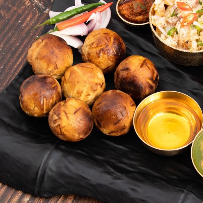 Litti Chokha Or Liti Choka From Bihar Jharkhand And Uttar Pradesh Is Stuffed With Chana Sattu. Served With Alu Or Aloo Baingan Bharta Desi Ghee Lehsun Adrakh Lehsoon Chutney Achar Mirchi And Pyaj