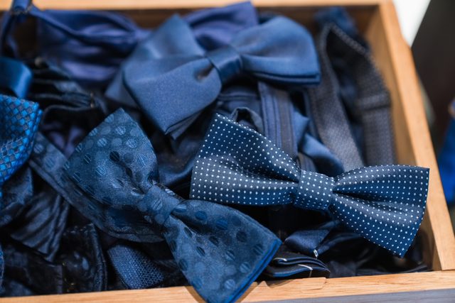 Close-up of blue bow ties in wooden container