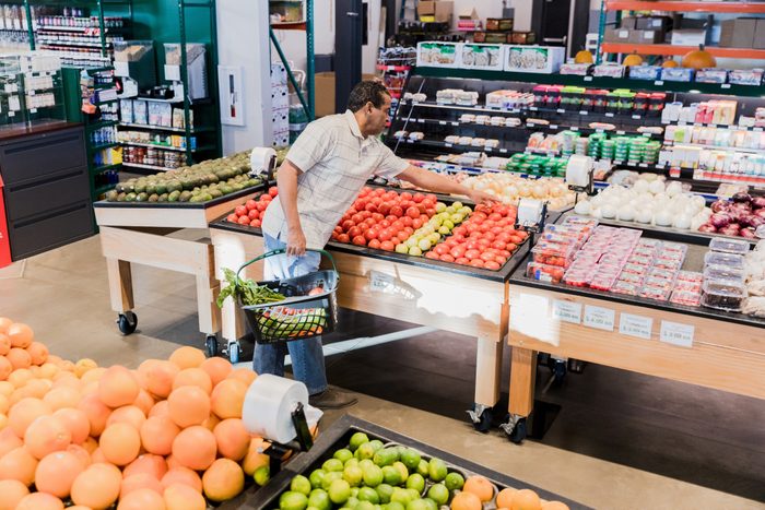 High angle view man selecting tomatoes in grocery store