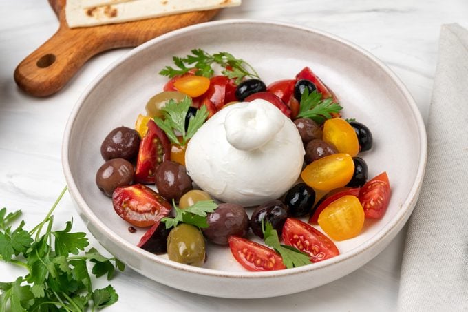 Caprese salad , Italian burrata cheese salad with tomatoes, olives and olive oil. healthy diet proteins vegetables
