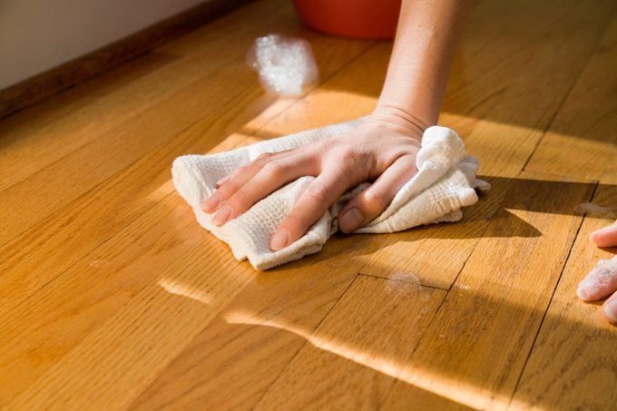 Hand clean wooden floor with rag